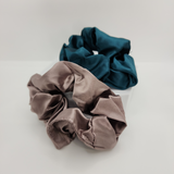 Two satin scrunchies, one brown and one blue, on a white background