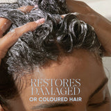 Close-up of a person washing their hair with shampoo lather, with text reading 'RESTORES DAMAGED OR COLOURED HAIR' and smaller text at the top saying 'SIGNATURE SENSES' and 'POWERED BY BIOTECH ACTIVES'.