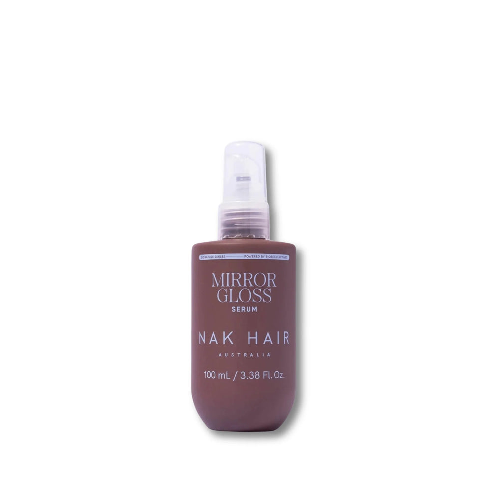 Nak Mirror Gloss Serum Helps smooth and restore the hair cuticle. a 100 mL bottle with a clear spray cap, shown on a plain white background.