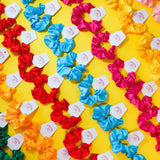 Colorful scrunchies arranged in a pattern on a yellow background