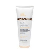 A white squeeze tube of Milk Shake Curl Passion Curl Perfectionist styling cream for curly hair, shown on a white background with a beige 'in salons now' badge in the top left corner.
