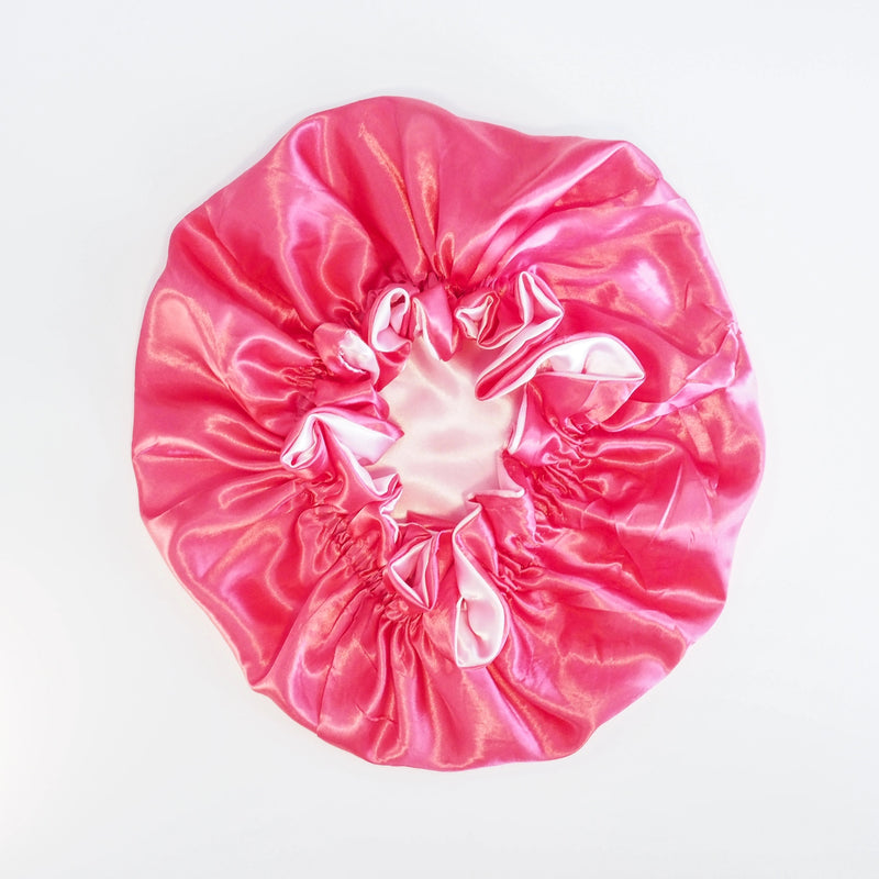 Pink satin sleeping bonnet on a white background